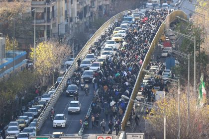 Shopkeepers and traders walk over a bridge during a protest against the economic conditions and Iran's embattled currency in Tehran on December 29, 2025. Some shopkeepers in Tehran closed their stores on December 29 in protest against economic hardships and sharp swings in Iran's embattled currency, Iranian media reported, following similar demonstrations a day earlier. Iran's currency has hit new lows on the unofficial market, with the US dollar trading at around 1.42 million rials on Sunday, compared to 820,000 rials a year ago and the euro nearing 1.7 million rials, according to price monitoring websites. (Photo by HANDOUT / FARS NEWS AGENCY / AFP)